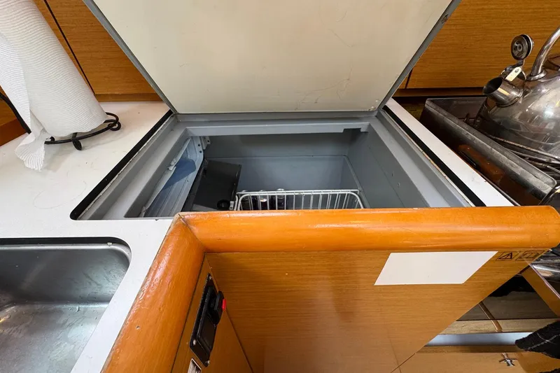 Slide: The Image of 2018 Jeanneau Sun Odyssey 389 yacht kitchen with open fridge, sink, and kettle. - 34