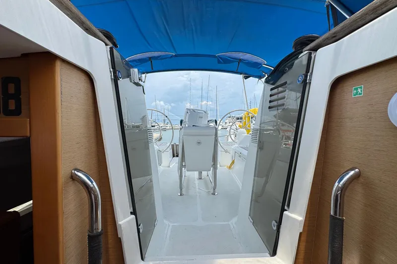 Slide: The Image of 2018 Jeanneau Sun Odyssey 389 cockpit with blue canopy and dual steering wheels. - 44