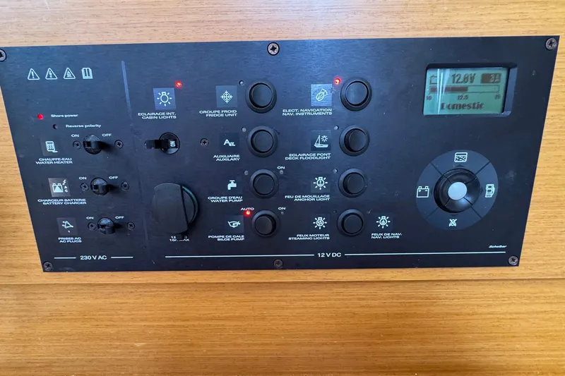Slide: The Image of Control panel of a 2018 Jeanneau Sun Odyssey 389 sailboat, featuring various switches and a digital display. - 45