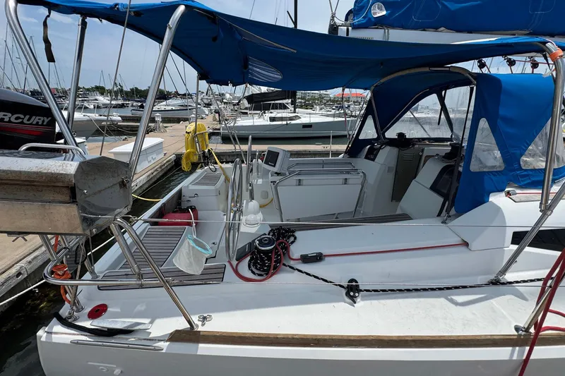 Slide: The Image of 2018 Jeanneau Sun Odyssey 389 sailboat docked, featuring blue canopy and modern cockpit design. - 6