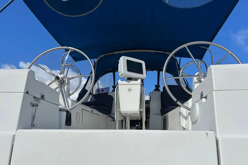 Slide: The Image of 2018 Jeanneau Sun Odyssey 389 cockpit with dual steering wheels and blue canopy. - 8
