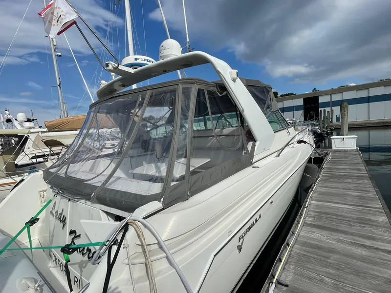 Slide: The Image of 1998 Formula 41 PC yacht docked at marina, featuring sleek design and enclosed cockpit. - 16
