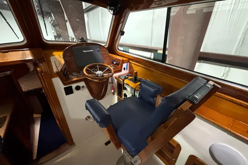 Slide: The Image of Helm of 2004 Hinckley 36 Picnic Boat EP with wooden steering wheel and navigation equipment. - 6