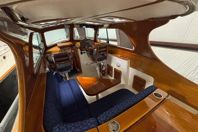 Slide: The Image of Interior of 2004 Hinckley 36 Picnic Boat EP with elegant wood finish and blue seating. - 9