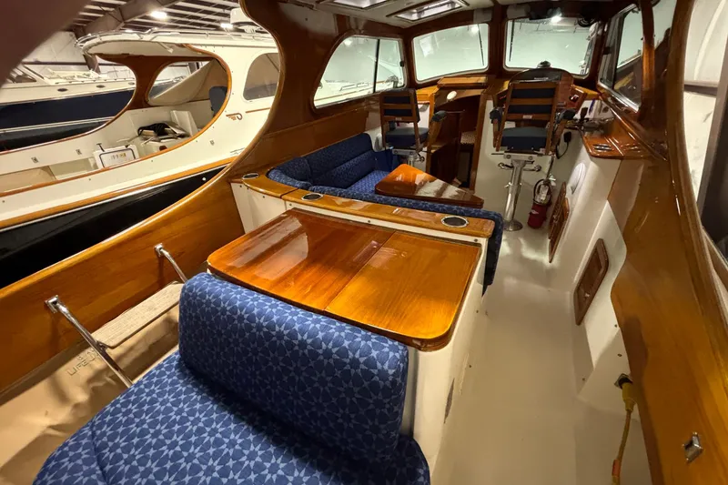 Slide: The Image of 2004 Hinckley 36 Picnic Boat EP interior with wooden finishes and blue patterned seating. - 10