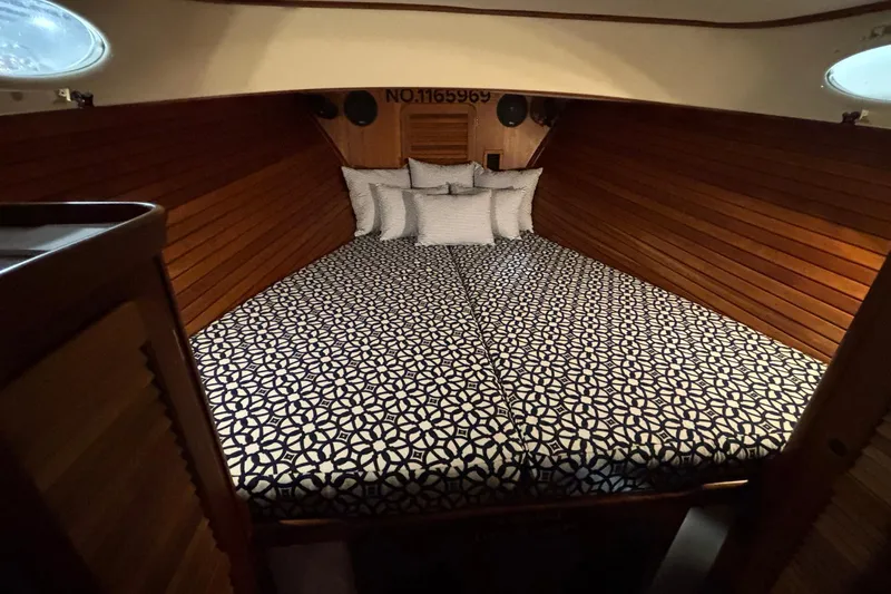Slide: The Image of 2004 Hinckley 36 Picnic Boat EP cabin with patterned bedding and wooden interior. - 3