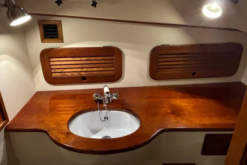 Slide: The Image of 2004 Hinckley 36 Picnic Boat EP interior with wooden sink area and lighting. - 5