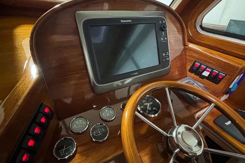 Slide: The Image of Helm of 2004 Hinckley 36 Picnic Boat EP with Raymarine display and wooden steering wheel. - 7