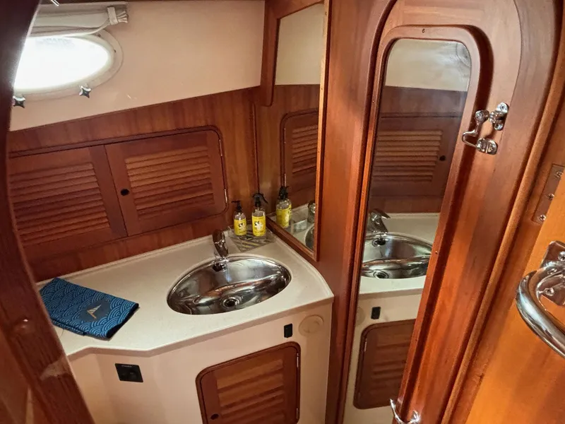 Slide: The Image of 2005 Hinckley Talaria 44 MY yacht bathroom with wooden cabinetry and stainless steel sink. - 6