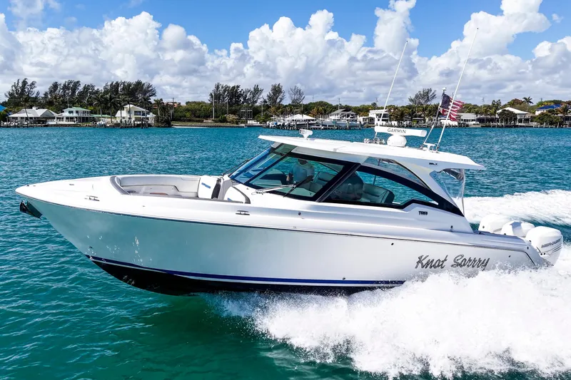 The Image of 2022 Tiara Yachts 38 LX cruising on blue water under a cloudy sky. - 1