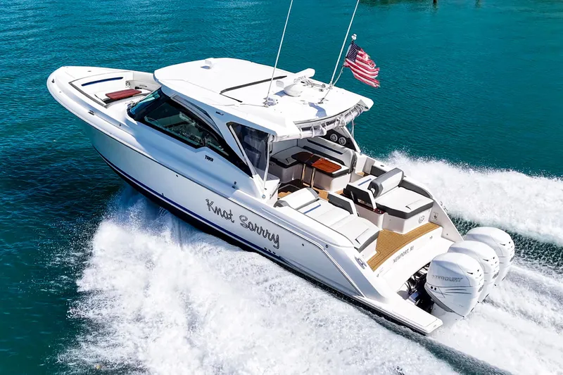 Slide: The Image of 2022 Tiara Yachts 38 LX cruising on clear blue water, displaying sleek design and powerful engines. - 5