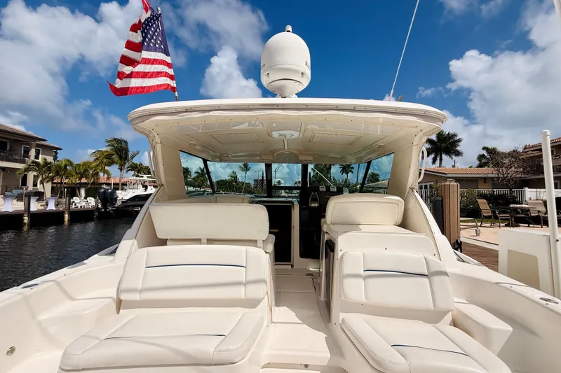 Slide: The Image of 2005 Tiara Yachts 3600 Sovran with American flag, docked under blue sky. - 11