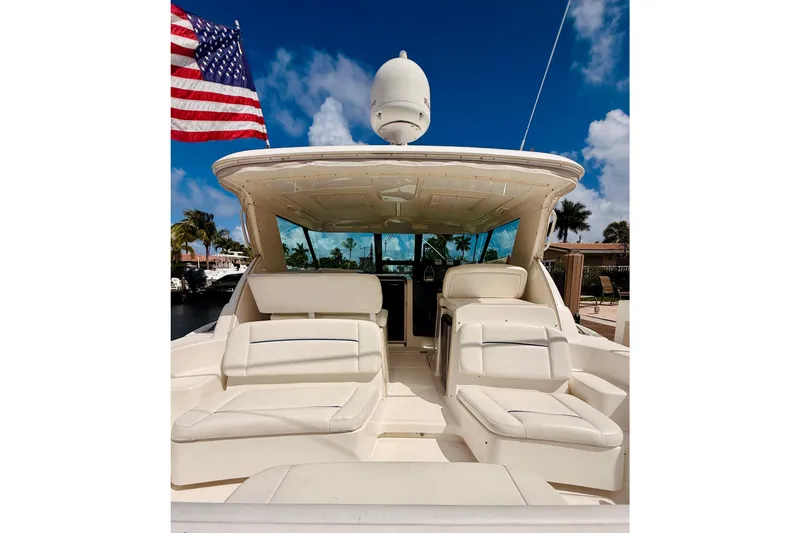 Slide: The Image of 2005 Tiara Yachts 3600 Sovran with American flag, luxurious seating, and clear blue sky. - 12