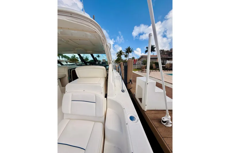 Slide: The Image of 2005 Tiara Yachts 3600 Sovran docked, showcasing sleek white seating and clear blue skies. - 21