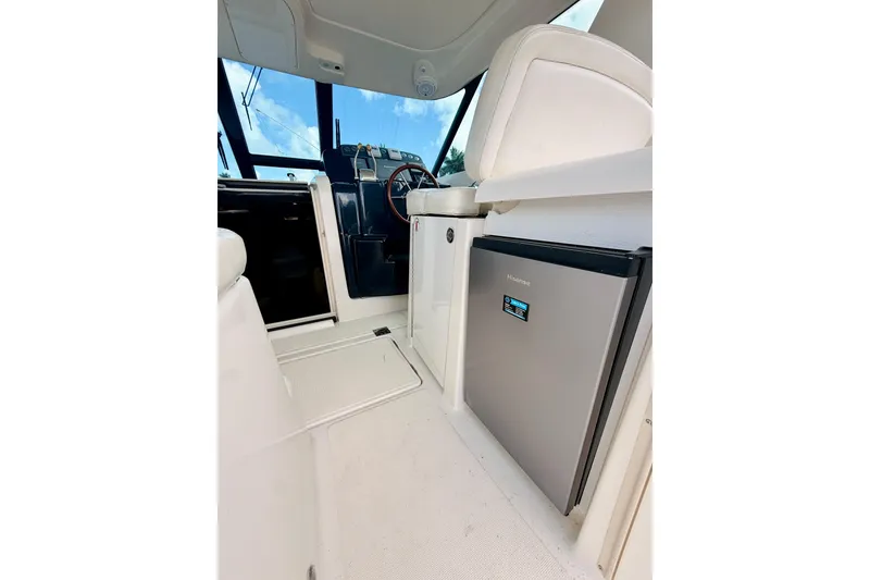 Slide: The Image of Interior of 2005 Tiara Yachts 3600 Sovran, featuring helm and compact refrigerator. - 24