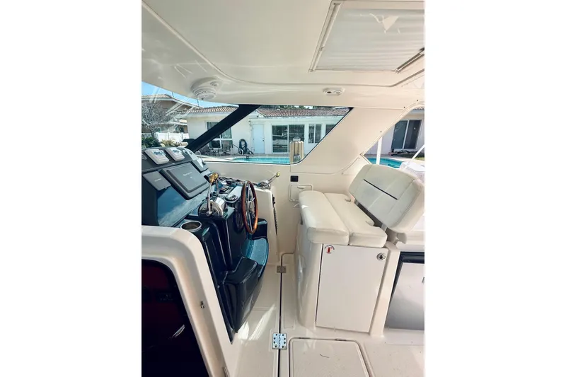 Slide: The Image of 2005 Tiara Yachts 3600 Sovran helm with white seating and modern controls. - 26