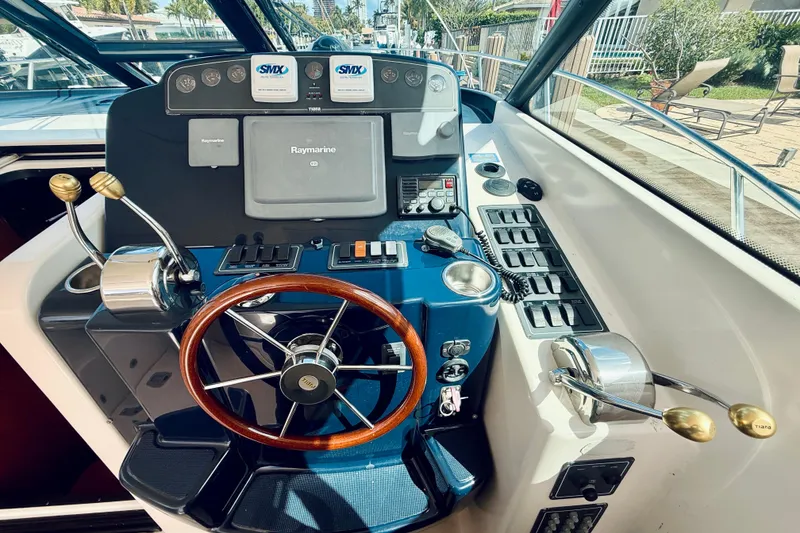 Slide: The Image of 2005 Tiara Yachts 3600 Sovran helm with Raymarine navigation and wooden steering wheel. - 30