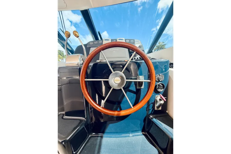 Slide: The Image of 2005 Tiara Yachts 3600 Sovran helm with wooden steering wheel and navigation controls. - 31