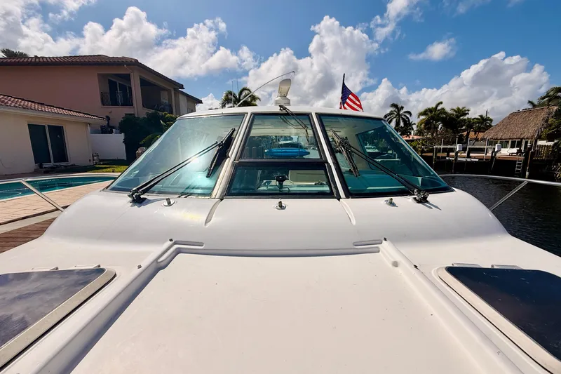 Slide: The Image of 2005 Tiara Yachts 3600 Sovran docked, showcasing sleek design and American flag. - 58