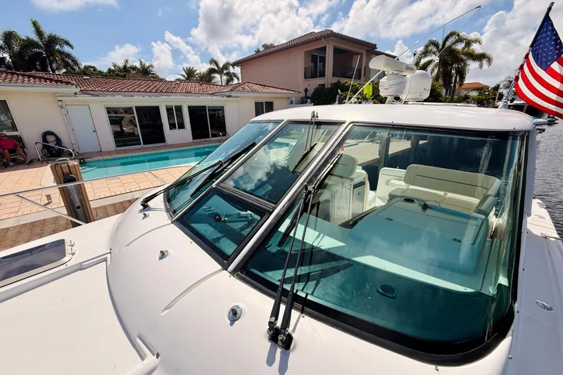 Slide: The Image of 2005 Tiara Yachts 3600 Sovran docked by a poolside home with American flag. - 61