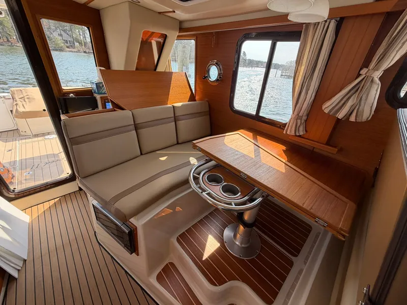 Slide: The Image of Interior of 2022 Ranger Tugs R-31 CB with wooden table and seating area. - 27