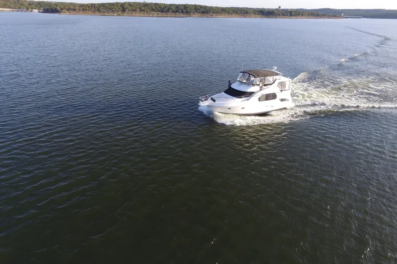 Slide: The Image of 2005 Silverton 43 Motor Yacht cruising on a serene lake under clear skies. - 17