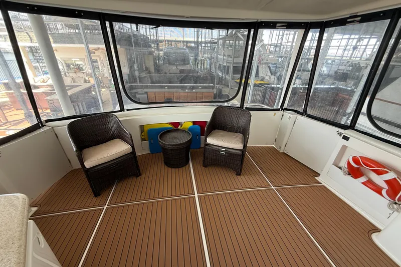 Slide: The Image of 2005 Silverton 43 Motor Yacht interior with wicker chairs and wooden flooring. - 21