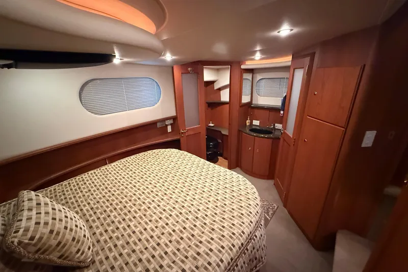 Slide: The Image of Luxurious 2005 Silverton 43 Motor Yacht bedroom with elegant wood finishes and cozy bedding. - 22