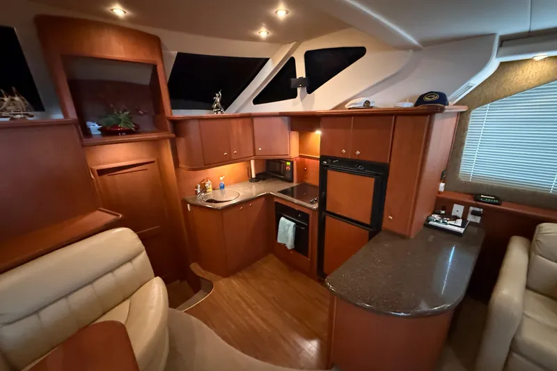 Slide: The Image of Luxurious 2005 Silverton 43 Motor Yacht interior with modern kitchen and elegant wood finishes. - 26