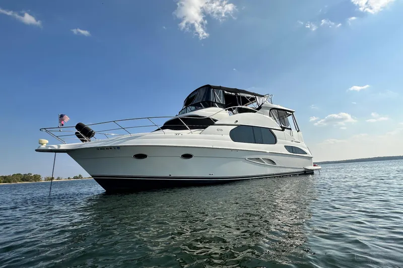 Slide: The Image of 2005 Silverton 43 Motor Yacht on calm water under a clear blue sky. - 3
