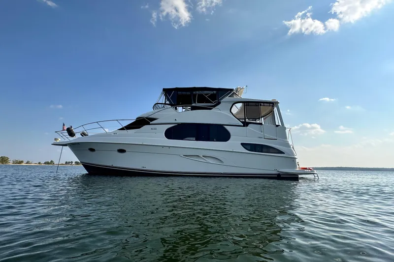 Slide: The Image of 2005 Silverton 43 Motor Yacht on calm water under a clear blue sky. - 5