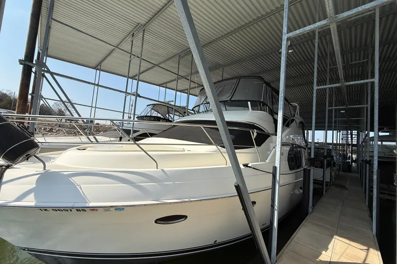 Slide: The Image of 2005 Silverton 43 Motor Yacht docked under a covered marina. - 9