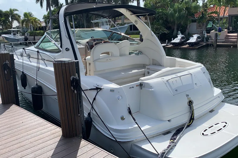 Slide: The Image of 2002 Sea Ray 360 Sundancer docked, featuring sleek design and spacious deck area. - 2