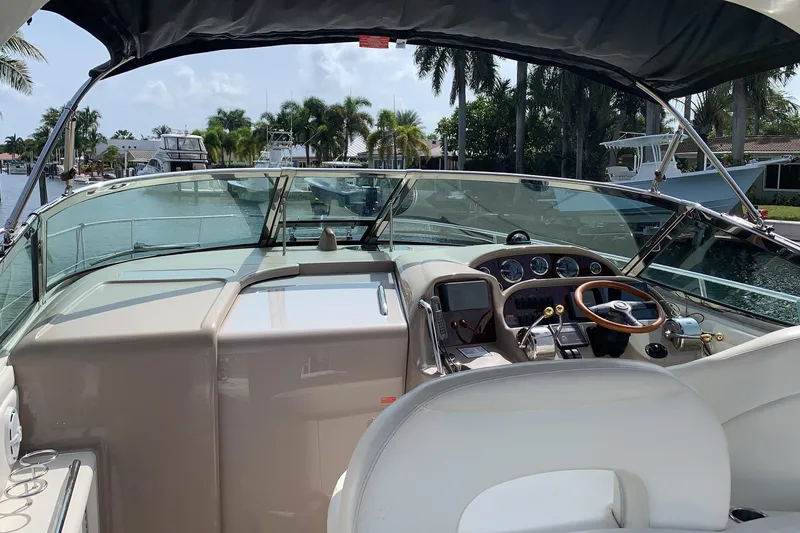 Slide: The Image of 2002 Sea Ray 360 Sundancer cockpit with steering wheel, gauges, and waterfront view. - 3