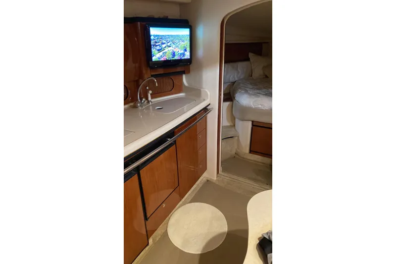 Slide: The Image of Interior of 2002 Sea Ray 360 Sundancer yacht with kitchenette and cozy sleeping area. - 5
