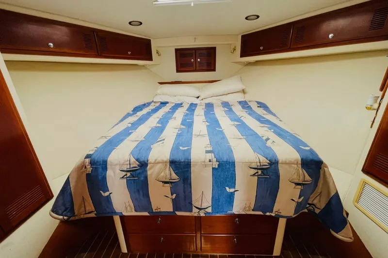 Slide: The Image of Cozy cabin interior of 1998 Cabo 45 Express with nautical-themed bedding. - 11