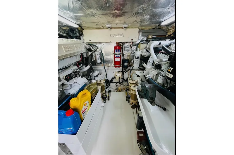 Slide: The Image of Engine room of 1998 Cabo 45 Express boat, featuring CAT machinery and maintenance supplies. - 12