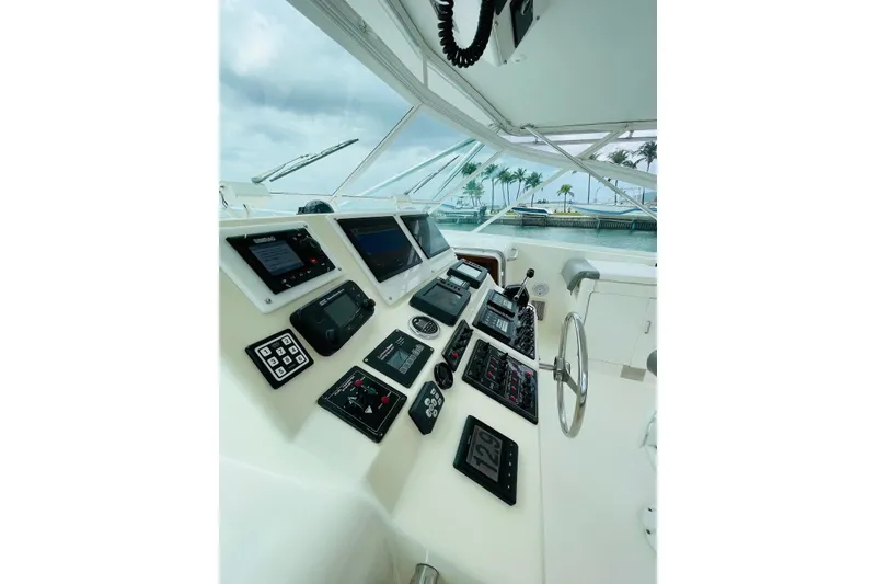 Slide: The Image of Control panel of 1998 Cabo 45 Express yacht with navigation equipment and steering wheel. - 5