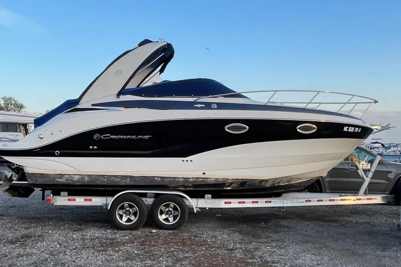 The Image of 2016 Crownline 264 CR boat on trailer, sleek design, parked outdoors. - 0
