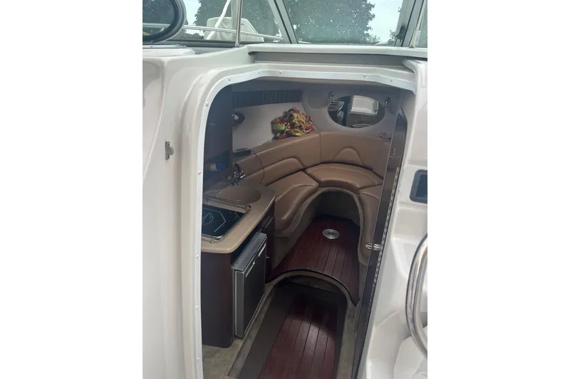 Slide: The Image of 2016 Crownline 264 CR cabin interior with seating and kitchenette. - 10