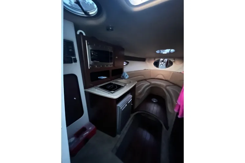 Slide: The Image of Interior of 2016 Crownline 264 CR boat with kitchenette and seating area. - 12