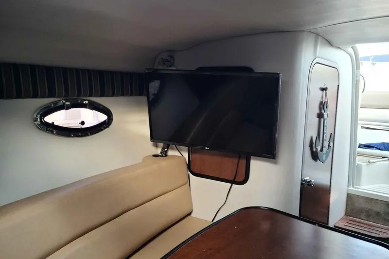 Slide: The Image of Interior of 2016 Crownline 264 CR boat with TV and seating area. - 13