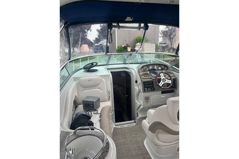 Slide: The Image of 2016 Crownline 264 CR boat interior with steering wheel and seating area. - 4