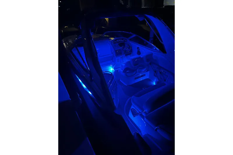 Slide: The Image of 2016 Crownline 264 CR boat interior with blue ambient lighting at night. - 7