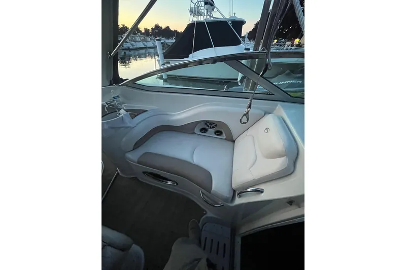 Slide: The Image of 2016 Crownline 264 CR boat interior with white seating and marina view. - 9
