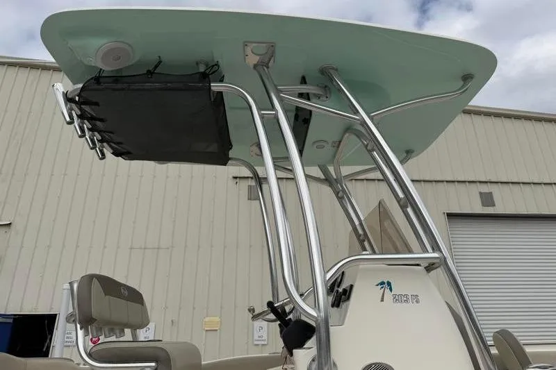 Slide: The Image of 2024 Key West 203 FS boat with T-top and seating, docked near a warehouse. - 15