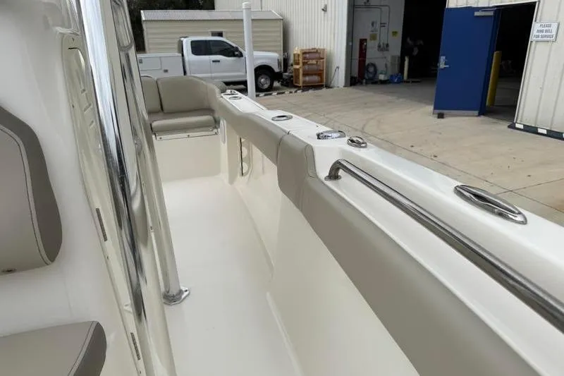 Slide: The Image of 2024 Key West 203 FS boat interior with seating and storage, parked near a garage. - 23