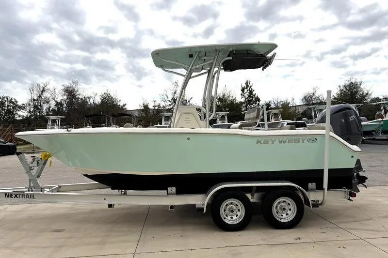Slide: The Image of 2024 Key West 203 FS boat on trailer, parked outdoors under cloudy sky. - 4
