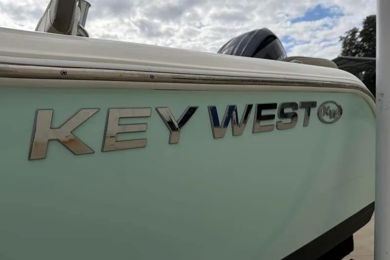 Slide: The Image of 2024 Key West 203 FS boat with logo, under cloudy sky. - 45