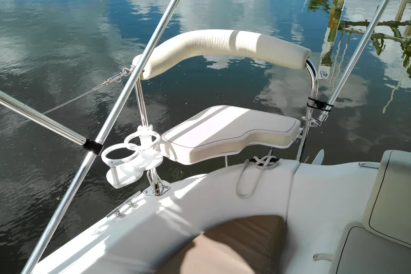 Slide: The Image of Cockpit of 2011 MacGregor 26M sailboat with cup holders and cushioned seating. - 12